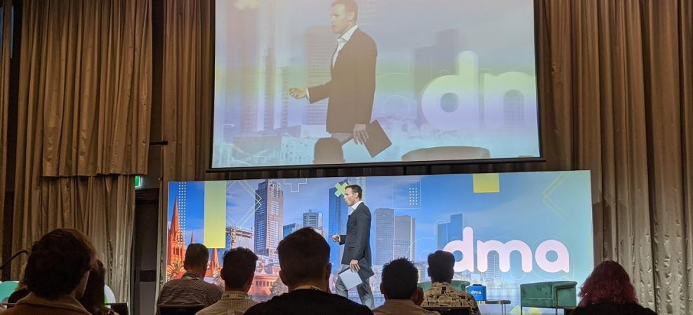 MC walking across stage at Digital Marketers Australia Conference 2020