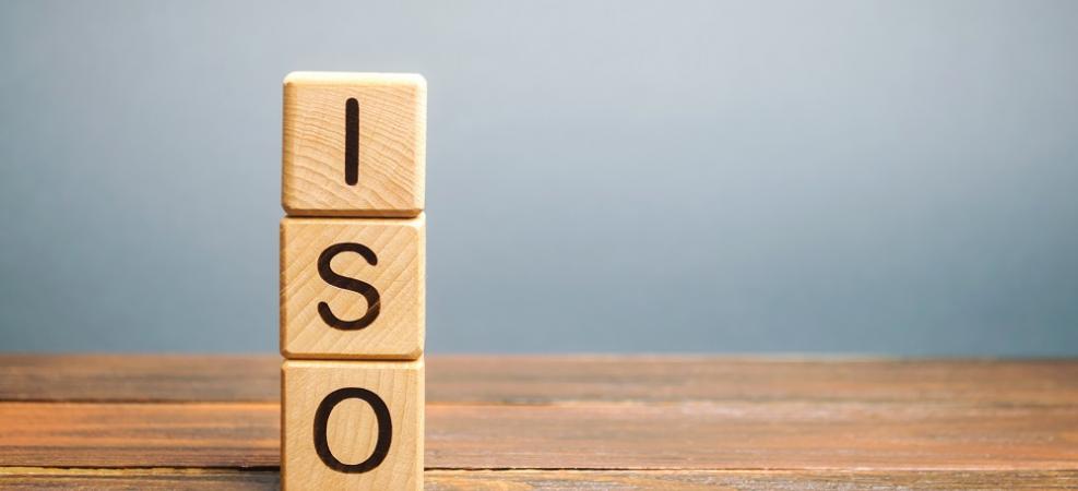 ISO cube letters stacked vertically on a desk with a grey background