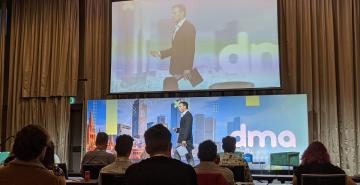 MC walking across stage at Digital Marketers Australia Conference 2020