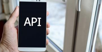 Man holding a phone that says API on screen 